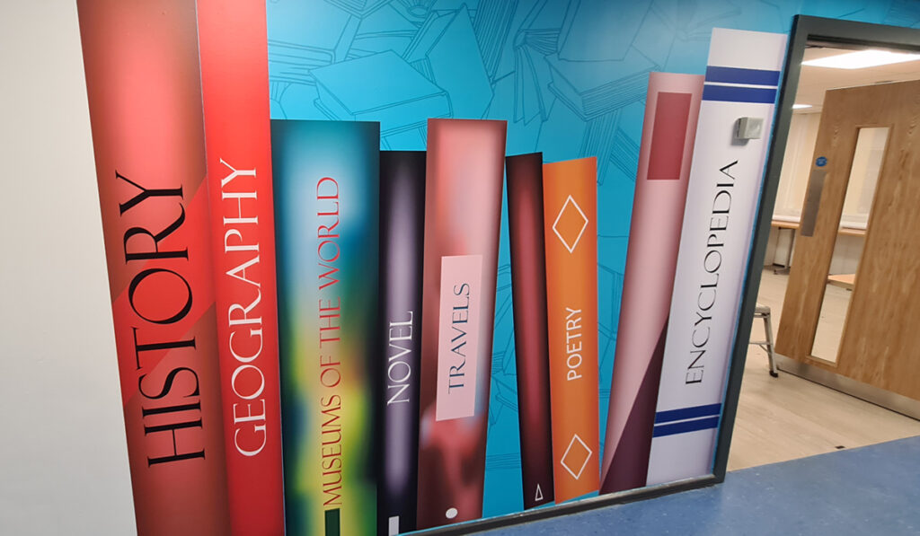 Mural at entrance to library shows an enlarged group of books on a shelf.